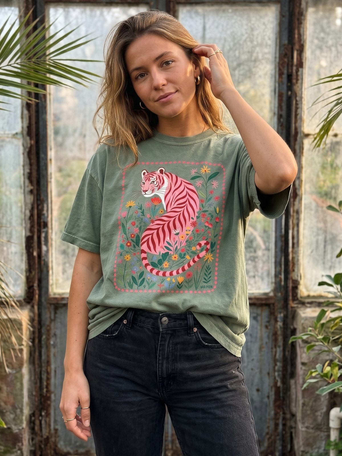 Woman in a greenhouse wearing the Botanical Pink Tiger tee